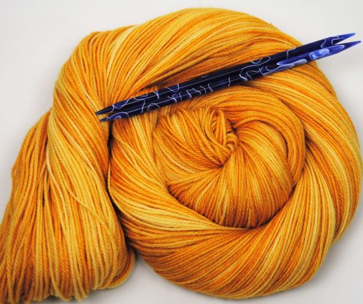 bright gold skein with blue needles