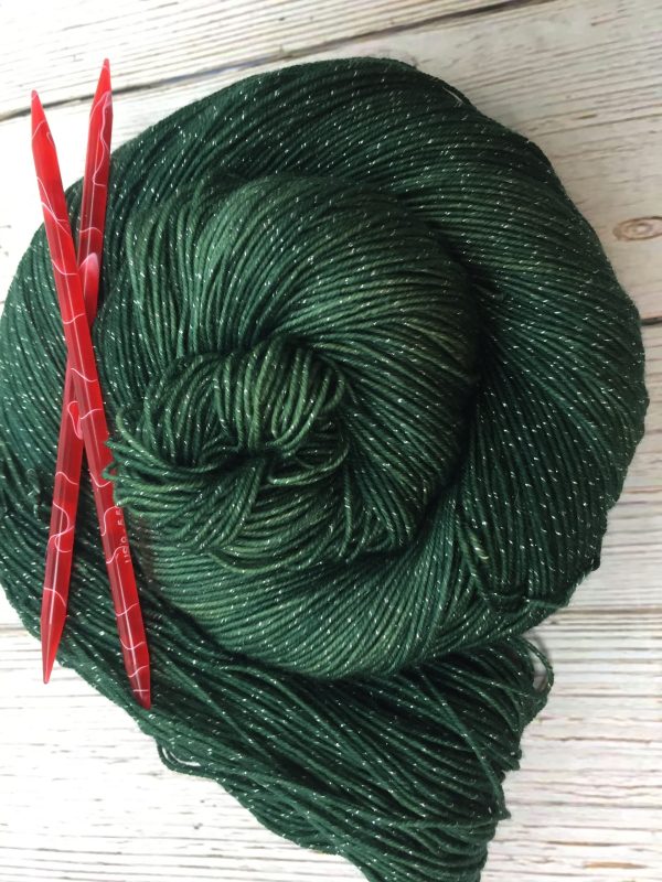 forest green yarn with metallic flecks with red needles