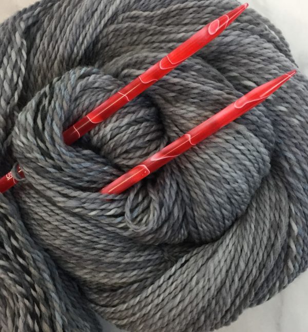 gray marled yarn with red needles