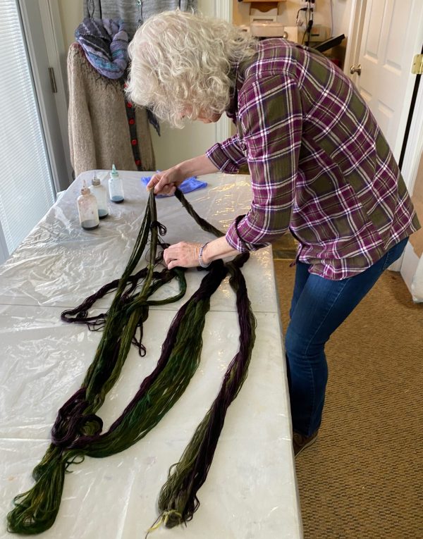 person working on their handpainted skein