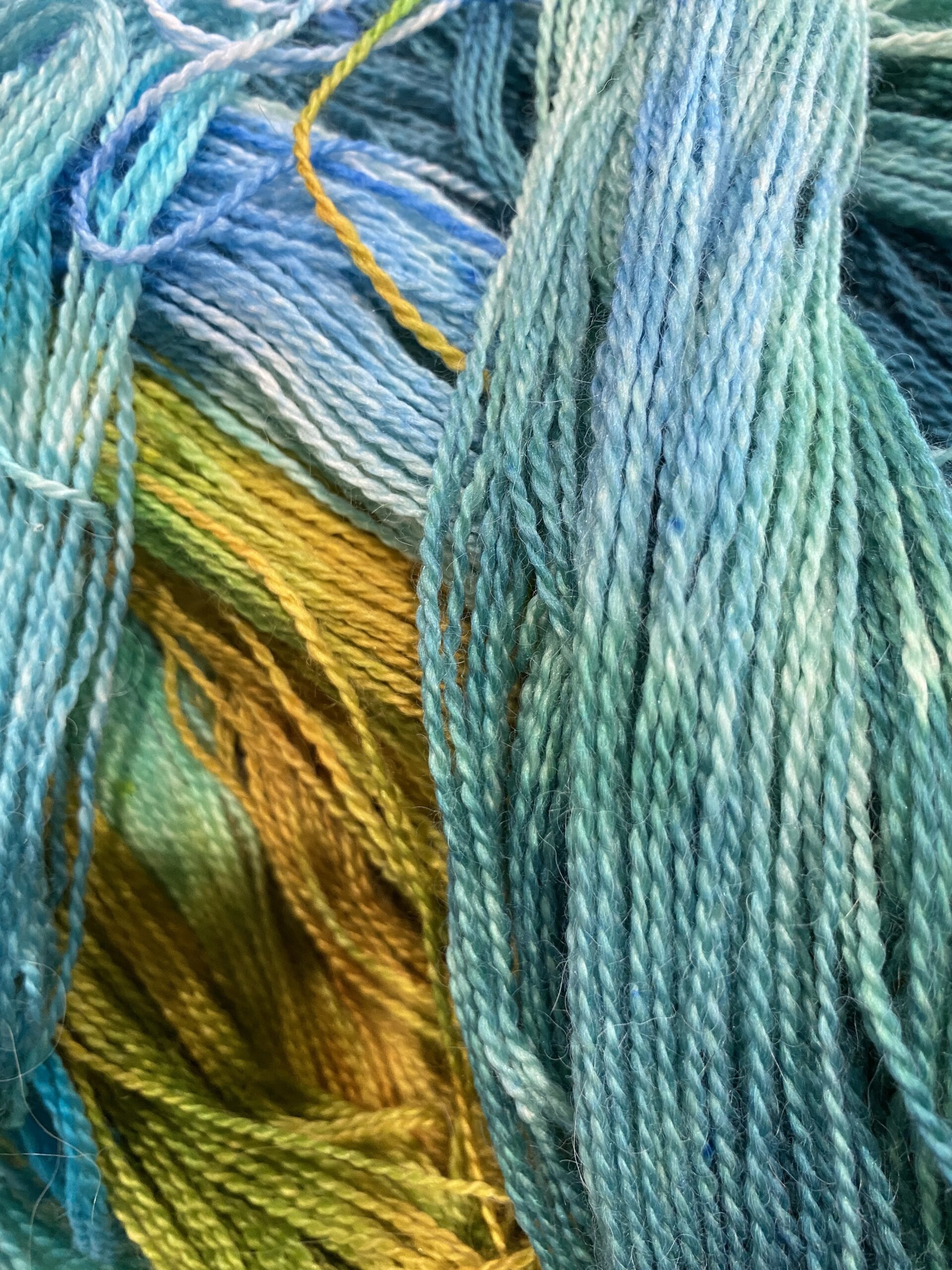 yarn pile in greens yellows and blues